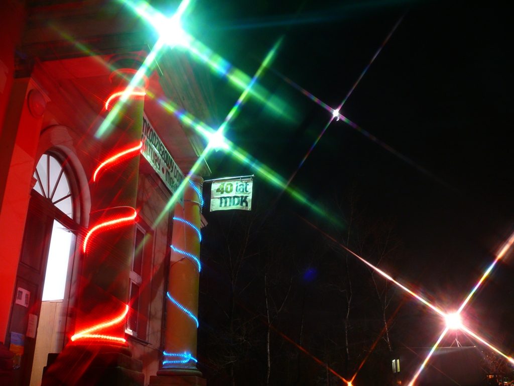 Budynek Młodzieżowego Domu Kultury przy ulicy Puławskiej 97. Wejście główne nocą z plakatem czterdziestolecie MDK